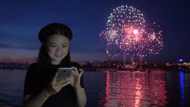 Dziewczyna przy użyciu telefonu w tle programu fireworks — Wideo stockowe