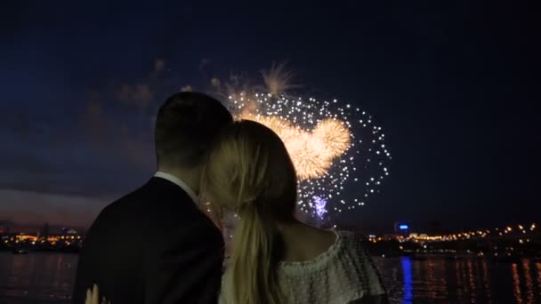 Pareja joven viendo los fuegos artificiales y abrazándose — Vídeos de Stock