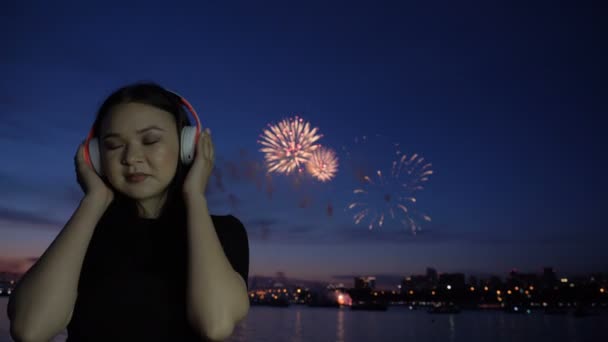 Fireworks and girl listening music in headphones — Stock Video
