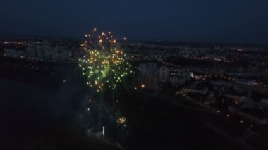 Işıklı şehir ve nehir üzerinde havai fişek