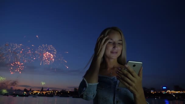 Mulher com telefone no fundo os fogos de artifício da cidade — Vídeo de Stock