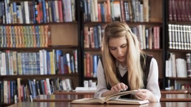 Güzel kız öğrenci Kitaplığı'nda bir kitap okuma