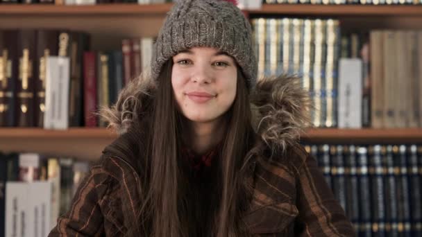 Chica retrato de cara en ropa de invierno en la librería — Vídeos de Stock