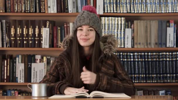 Πρόσωπο πορτρέτο κορίτσι με χειμωνιάτικα ρούχα στο βιβλιοπωλείο — Αρχείο Βίντεο