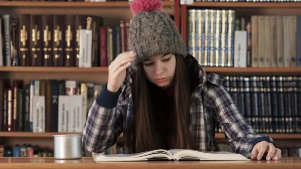 Estudiante niña leyendo libro en la biblioteca universitaria — Vídeos de Stock
