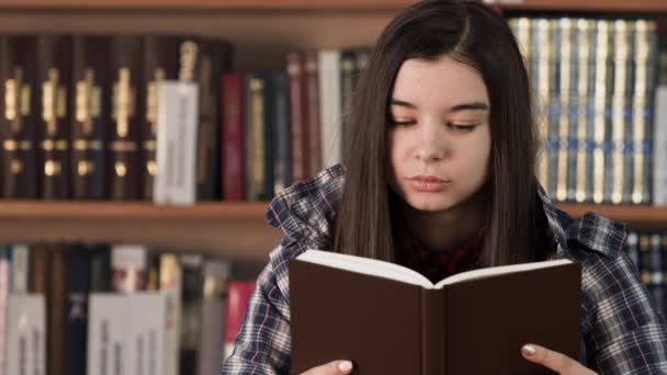 Усміхнена дівчина насолоджується історією тростини в книгарні крупним планом — стокове відео