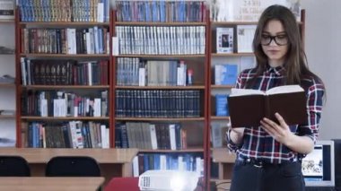 Kitap ve eğitim video ile çalışan genç kadın