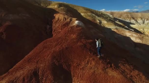 Mujer excursionista enciende una bomba de humo en montañas rojas — Vídeo de stock