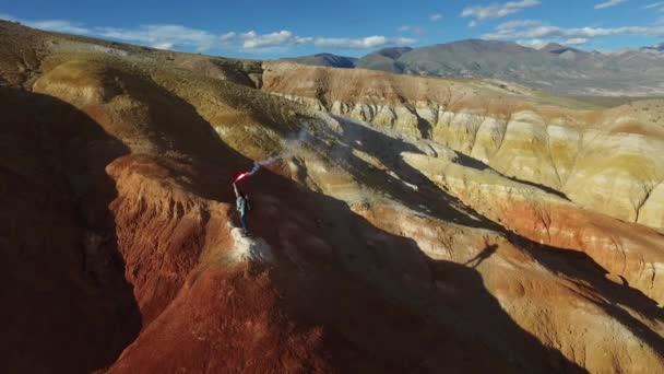 Női természetjáró fény egy füst bomba piros-hegység — Stock videók