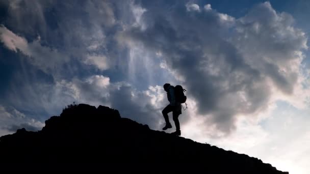 Silhouet wandeling naar de berg klimmen bij zonsondergang — Stockvideo