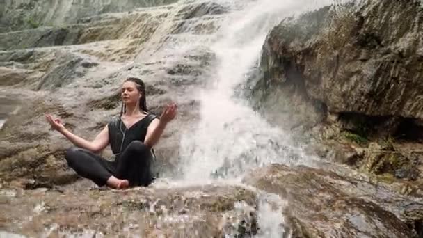 Kadın taş şelale ile yoga yaparken — Stok video