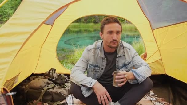 Homem feliz bebendo chá na tenda no acampamento manhã — Vídeo de Stock