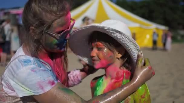 Tienermeisje knuffel zus op Holi festival van kleuren — Stockvideo