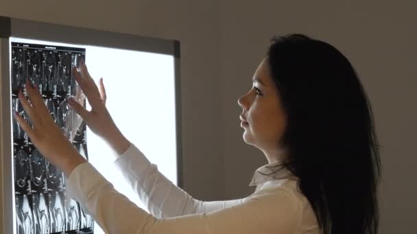 Женщина-врач рассматривает изображение магнитно-резонансной томографии на экране — стоковое видео