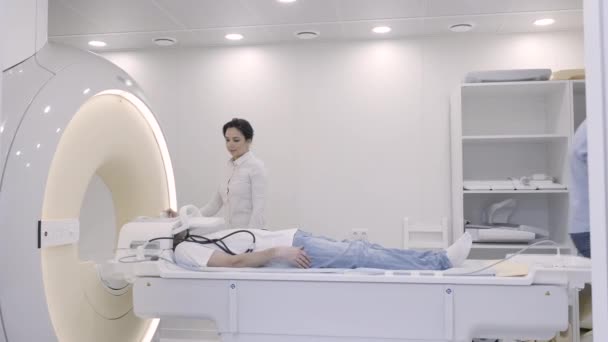 Doctora controlando los diagnósticos de resonancia magnética moviendo al hombre dentro del tubo — Vídeos de Stock