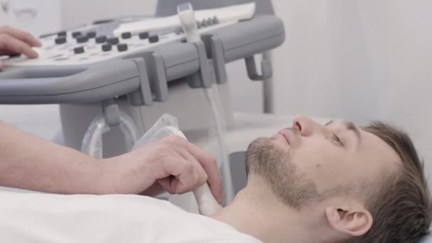 Homem deitado durante o diagnóstico de ultra-som para a tireóide — Vídeo de Stock