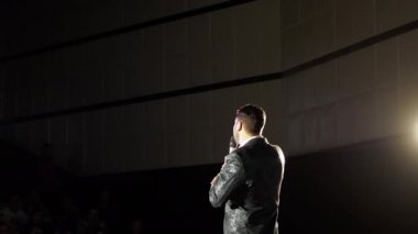 Kişi duygusal mimik ve konferans salonu seyirci ile tartışıyor