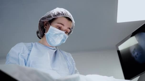 Female surgeon doctor face at operation in hospital room close up — Stock Video