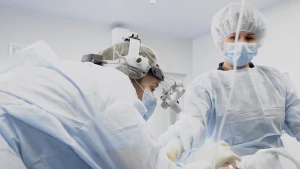 ENT surgeon doctor with assistants working in operation room — Stock Video