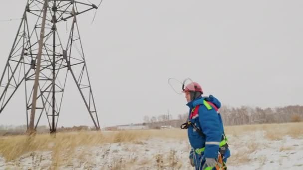 Elektricien in overalls en helm gaan repareren de spannings draden — Stockvideo