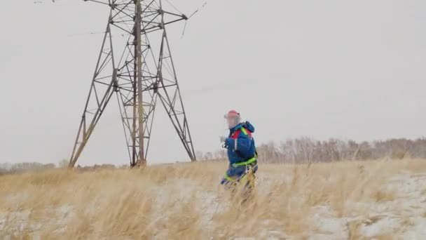 Elektrikář opravovat dráty u elektrické energie na poli ve sněhu — Stock video