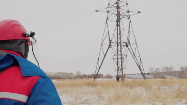 Человек собирается отремонтировать кабель напряжения электрической башни — стоковое видео
