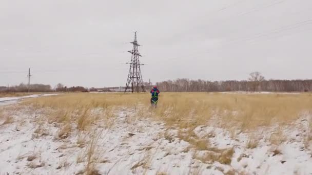 Elektrikář, který jede k elektrické lince na sněžním poli — Stock video