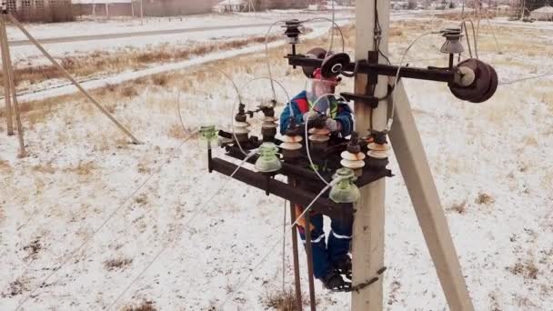 Elektricien reparman werkt aan de toren bij het elektrisch station — Stockvideo