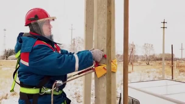 Man moving to the pole for repair voltage cable at electric station — Stock Video