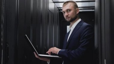 Sunucular ile veri merkezinde yönetici olarak çalışan gülümseyen adam