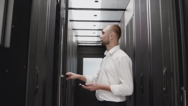Administrador de sistema abre rack de servidor para diagnóstico com telefone — Vídeo de Stock