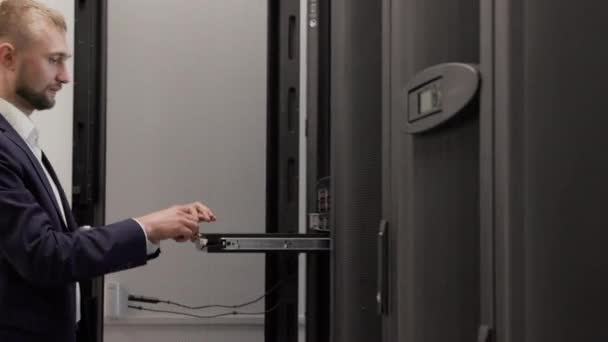 Server ingenjör som arbetar i datacenter rum med bärbar dator — Stockvideo