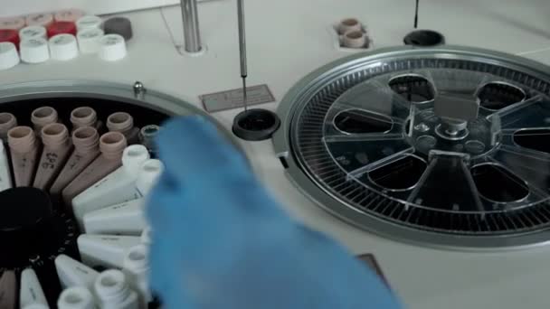 Τα χέρια σε γάντια βάζουν σωλήνες αίματος σε ρομπότ φυγοκεντρήσεως για έρευνα — Αρχείο Βίντεο