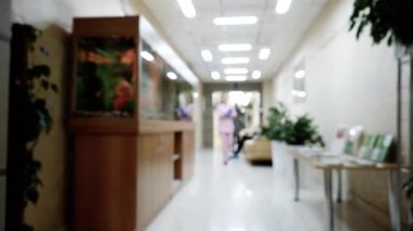 Pembe üniforma yürüyüş kadın doktor ile klinik koridor Blur arka plan.