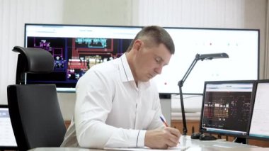 Dispatcher enerji sektöründe mühendislik sistemlerinin kontrol odasında çalışıyor.