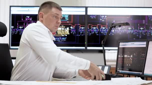 Odborný muž pracuje v řídící místnosti a volá smartphone na jadernou elektrárnu. — Stock video