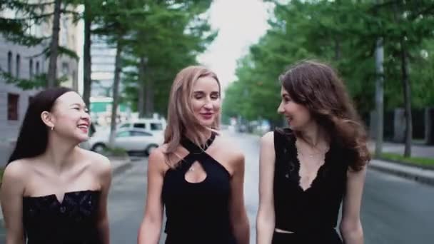 Три счастливые мульти-этнические девушки друзья идут на вечеринку ночной клуб ходить по улице города . — стоковое видео