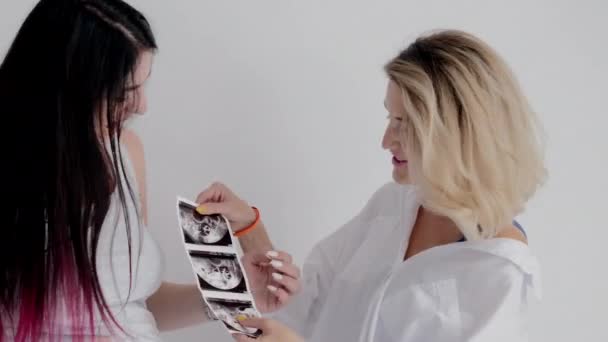 Mãe e filha grávida conversando e olhando para fotos de ultra-som . — Vídeo de Stock