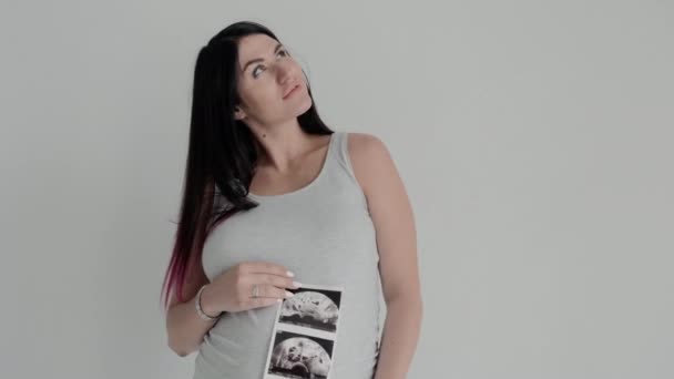 Pregnant Woman in Gray Shirt Poses. Portrait of Mother with Scan of Baby. — ストック動画
