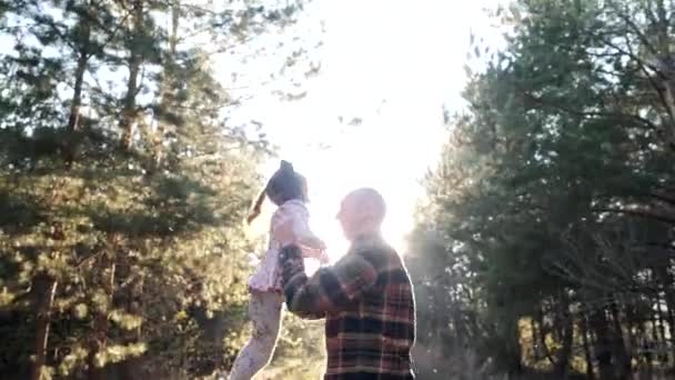 Веселые активные игры счастливого старого деда кружит маленькая внучка в лесу — стоковое видео