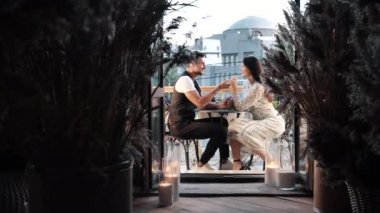 Romantik aşk randevusu, genç, mutlu, eğlenceli bir çiftin restoran balkonunda gülmesinden bahsediyor.