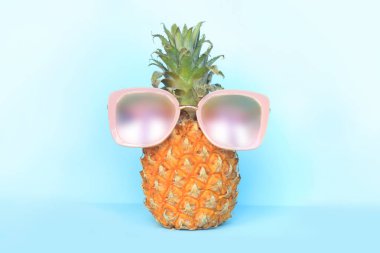 Turkuaz arka plan üzerinde güneş gözlüğü sulu ananas