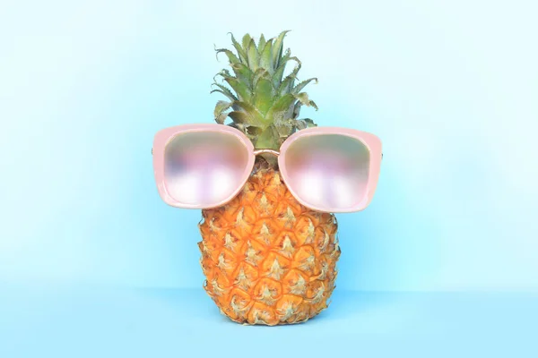 Succosa ananas in occhiali da sole su sfondo turchese — Foto Stock