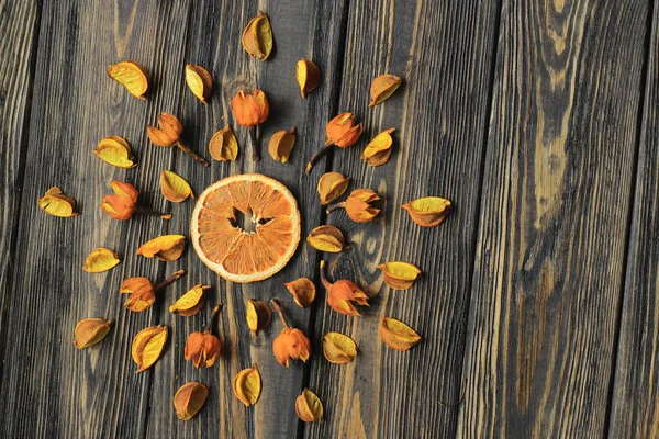 Orangefarbene und trockene Hibiskusblüten auf Holzgrund — Stockfoto