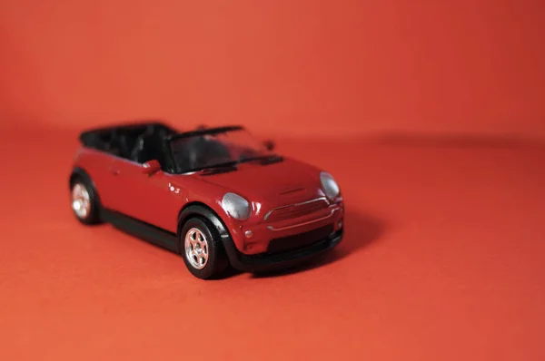 Juguete pequeño SUV rojo, coche de juguete para niños con una parte superior abierta sobre un fondo rojo — Foto de Stock