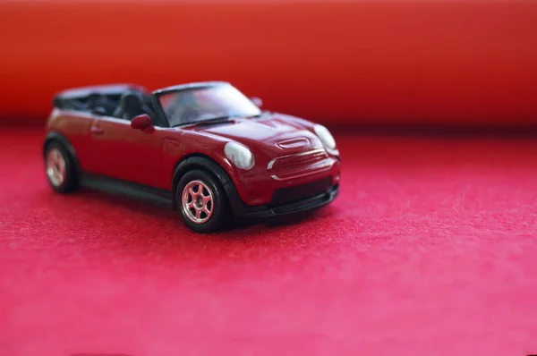 Small toy red SUV, childrens toy car with an open top on a red background — Stock Photo, Image