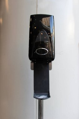 Fast food alanının girişindeki duvarın yanındaki umumi alanda el dezenfektanı. El dezenfektanı.