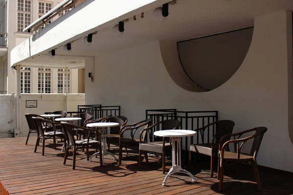 Tel Aviv 'in merkez caddesindeki açık bir verandada boş masalar ve masalar. Büyük şehirlerde bir karantina dönemi. Eğlence ve eğlence merkezinin kapanışı. Şabat 'tan önce kapalı kafe.