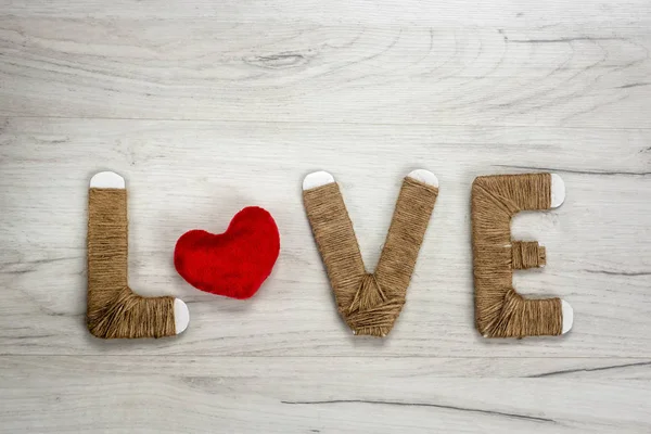 文字爱与毛绒绒的心脏形状在木背景 — 图库照片