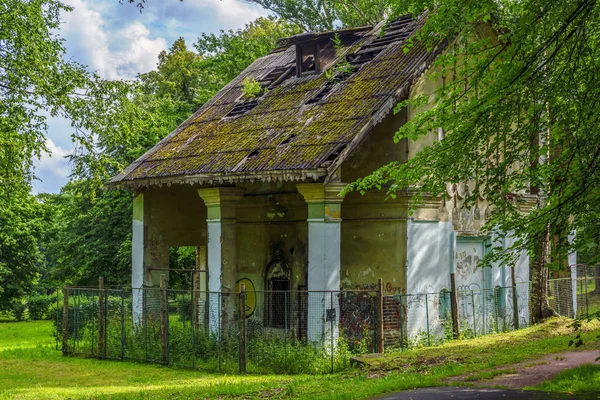 Vintage forlorn house deep in city park with lush green foliage